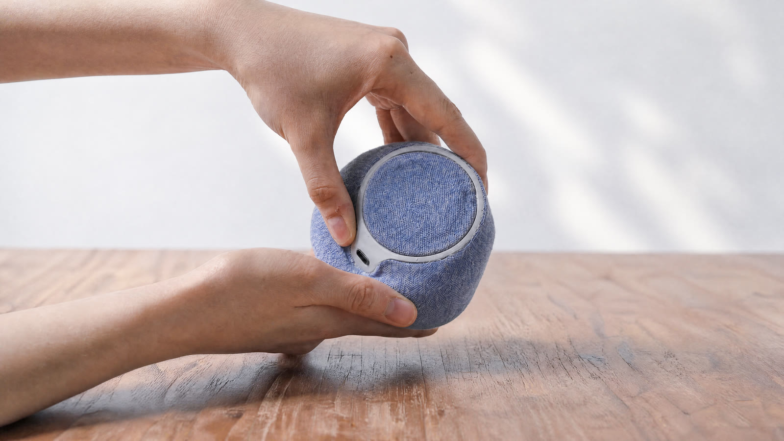 Two hands pressing NEST on a wooden table
