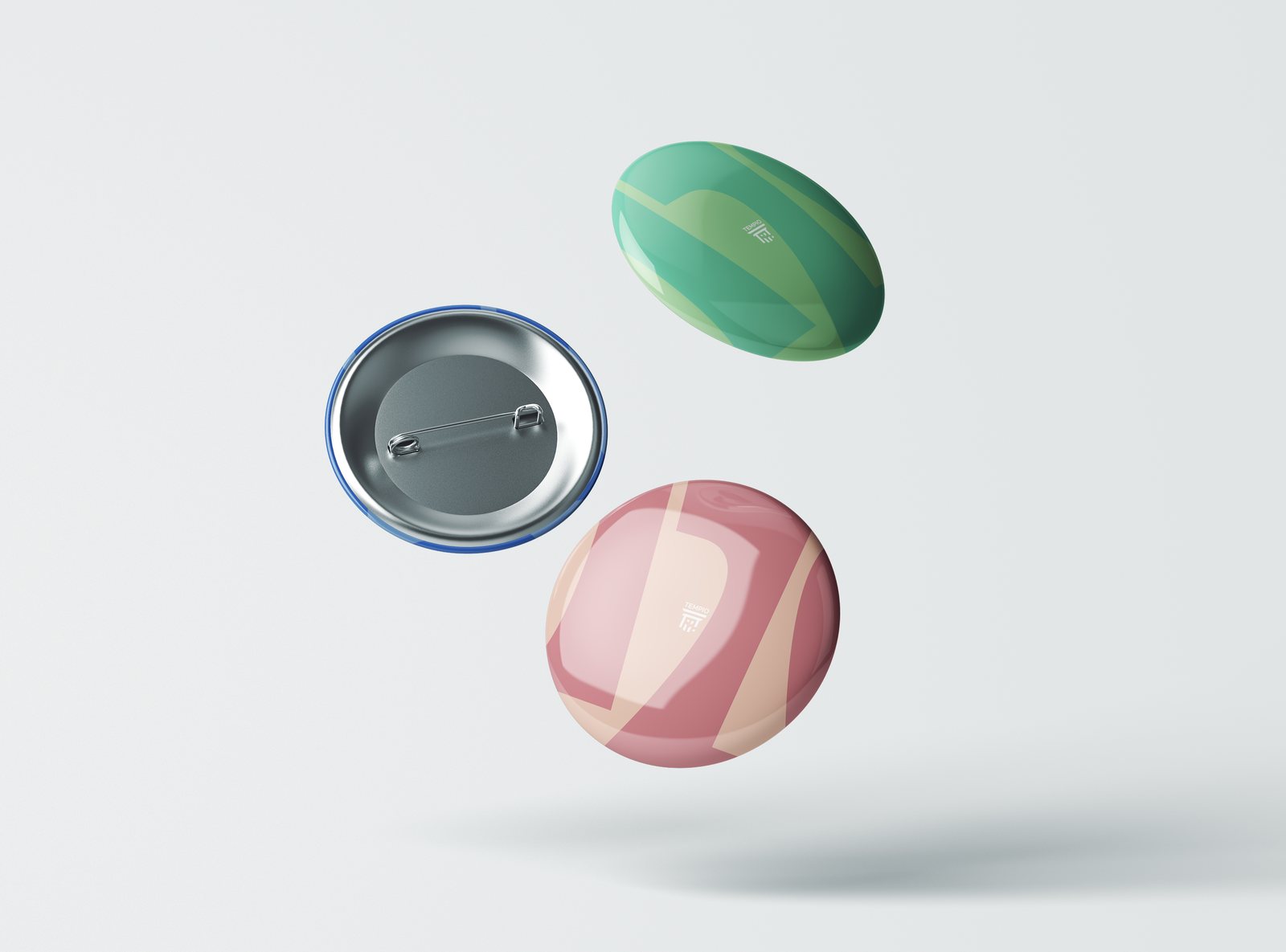 Three pin badges in green and pink
